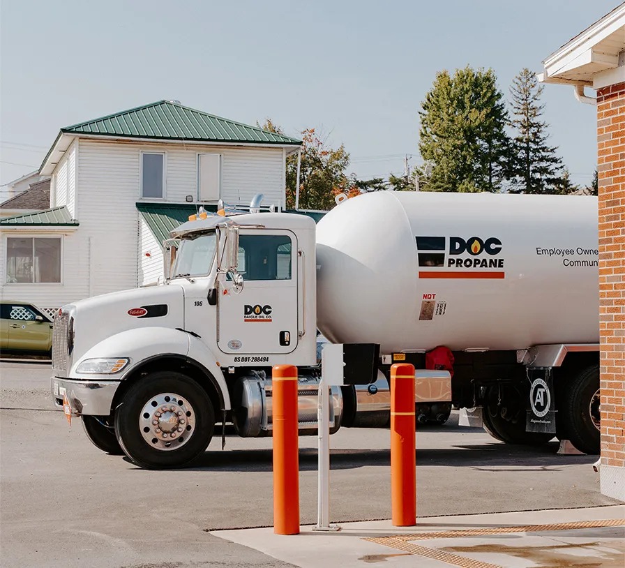 white fuel truck with Daigle logo parked outside an old office building.