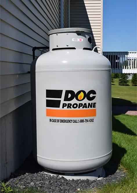 mid-sized propane tank with the DOC logo next to a suburban house
