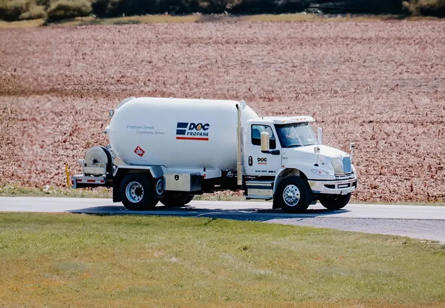 daigle fuel truck driving down a rural road next to a corn field