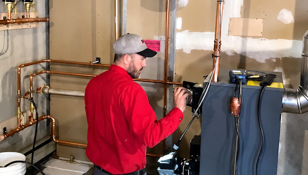 daigle employee in a basement looking at heating equipment