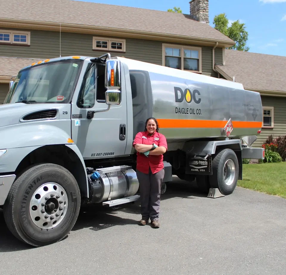 daigle employee Amy leaning against her delivery truck in a customers drive way
