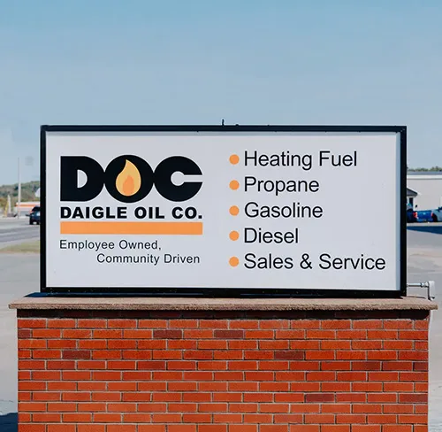 sign outside a DOC gas station showing that this locations provides heating fuel, propane, gasoline, diesel, and sales/service